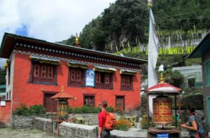 Lukla to Namche Bazaar trek passing Buddhist Monastery at Ghat village with Prayer wheel and holy Flags